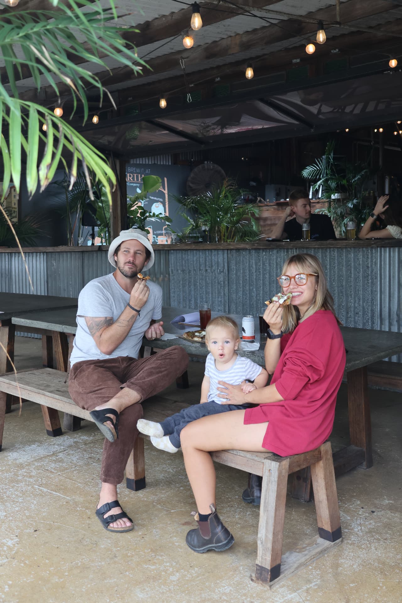 Family enjoying Tribe Pizza at an outdoor long-table lunch